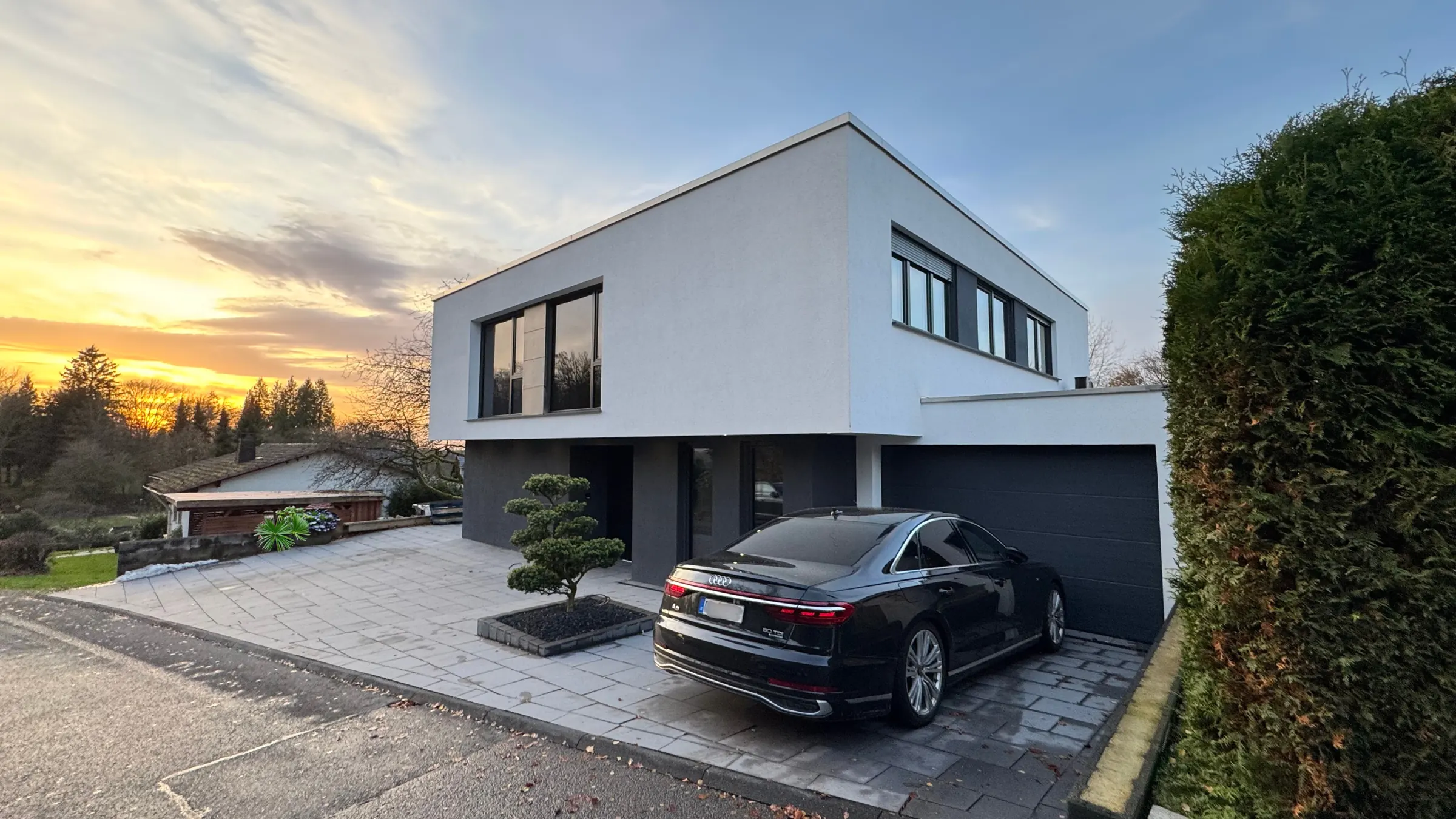 Modernes Einfamilienhaus mit Flachdach bei Sonnenuntergang